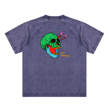 Load image into Gallery viewer, A washed navy short-sleeve raglan t-shirt featuring a colorful graphic of a green skull with yellow teeth, lightning bolts, and a blue dotted pattern on the chest, with 'Pop America' text printed below.
